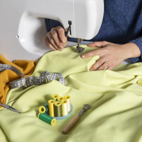 close-up-hands-sewing-with-machine-scaled